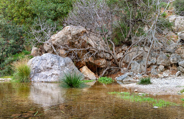 A small cave in the rocks near the waterfall with green water pond. Toll del Baladre, Las Fuentes del Algar / Algar fountains, Callosa de Ensarria, Alicante province, Spain.