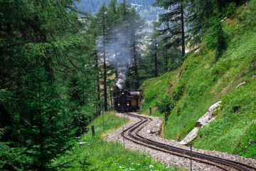 Alte Dampflokomotive fährt über den Furkapass in den Schweizer Alpen. Zahnradbahn in den Berge.