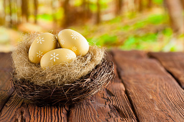 Easter eggs in the nest on wooden table