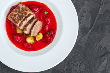 duck breast, vegetables, berry sauce and microgreen (main dish). food background. top view