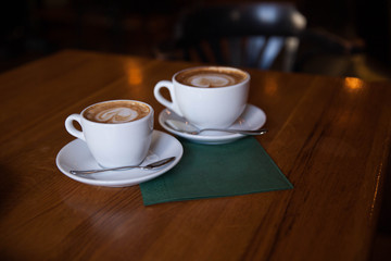 Fototapeta premium Two cups of cappuccino on a wooden table