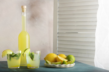 Bottle of homemade juice with ginger and lemon on light background. Horizontal