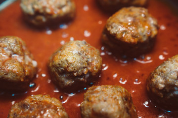 chicken meatballs with tomato sauce cooked in a pan. close up of meatballs with glaze