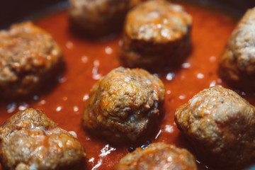 chicken meatballs with tomato sauce cooked in a pan. close up of meatballs with glaze