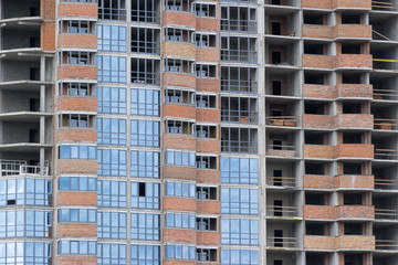 Naklejka premium new building multistoried concrete house with brick walls and glass windows