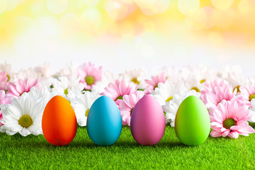 Easter eggs and pink and white flowers on abstract background