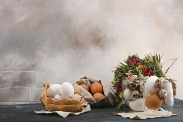 Quail eggs in glass container, white in paper and yellow in canvas bag and bouquet of dried flowers.