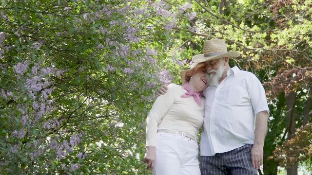 Senior man and senior woman enjoy each other in summer park