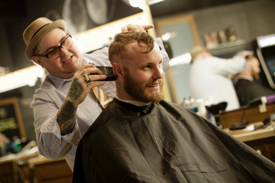 Barber shaves back of client's head
