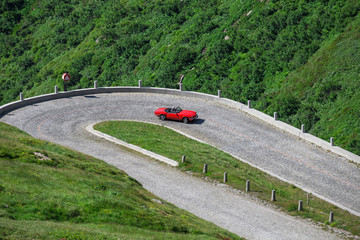 Autos fahren auf einer kurvigen Strasse in den Alpen