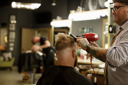 Barber Styles Hair With A Blow Dryer