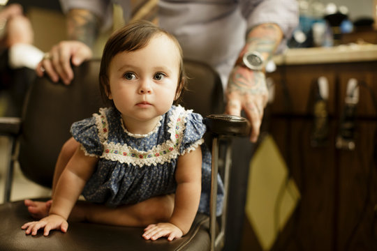 Toddler sits in barbershop chair
