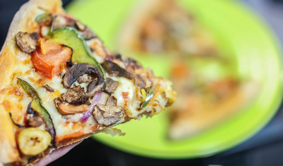 slice vegetarian vegetable pizza with sweet pepper, mozzarella cheese, onion, olives, tomatoes, champignons, tomato sauce