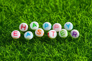 Happy Easter - colorful lettering on a grass background