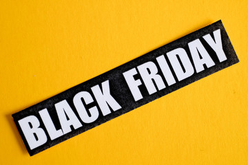 Black Friday sticker on a yellow background. Close up.