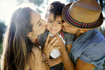 Mother and father kiss their young son