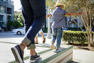 Rear view of father and son walking on top of wall