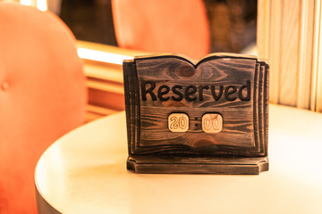 A tag of reservation placed on the wood table. 