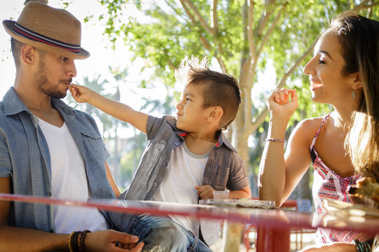 Young boy feeds snack to father