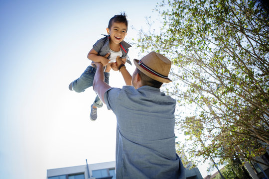 Father holds son up in the air