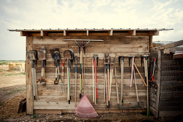 Farm tools hanging on a wood shed