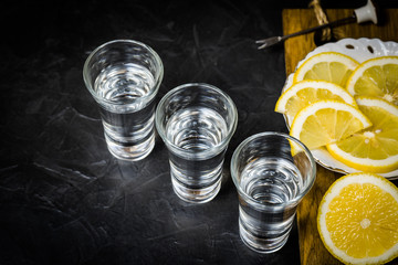 Strong alcohol poured into a glass. lemon slicing.