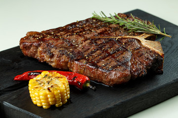 steak fried tibon with corn on the table.