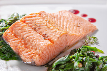 A piece of steamed salmon steak with spinach