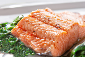 A piece of steamed salmon steak with spinach