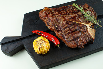 steak fried tibon with corn on the table.