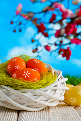 Easter eggs in the nest and wooden table on nature background