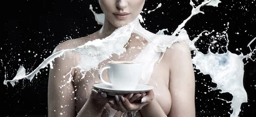 Gartenposter Milch spritzt gegen eine nackte Frau, die eine Tasse Kaffee hält © konradbak