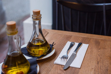 oil bottles and cutlery on the wood table in a cafe