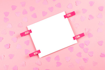 Sheet of paper on pink decorated background.