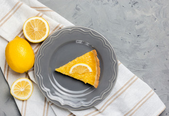 Plate with piece of tasty lemon pie on stone background, copy space.