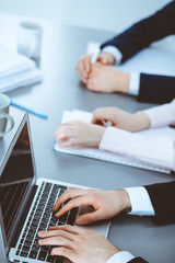 Group of business people working together in office. Man hands typing on laptop computer