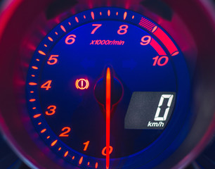 Close up shot of a speedometer in a car. Blue illuminated.