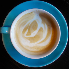 Cappuccino coffee served in a cup. Beautiful blue cup.