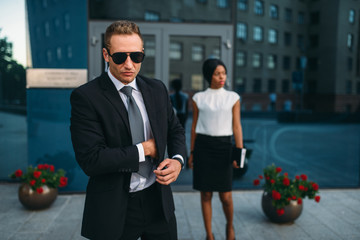 Bodyguard in suit and sunglasses, female VIP