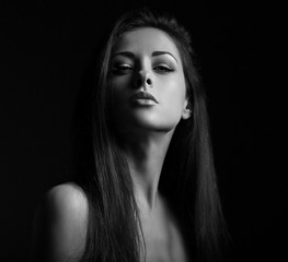 Beautiful makeup seriois woman with long hair looking sexy with half shadow on the face. Closeup...