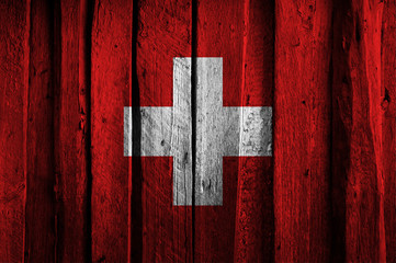 Swiss flag on background of old wooden planks.