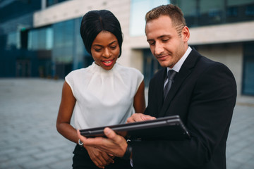 Business woman and businessman looks on laptop