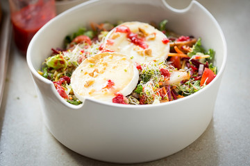 Salad with lettuce, fried pears, camembert, walnuts, red onion, tomatoes and raspberry vinaigrette dressing