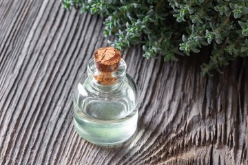 A bottle of thyme essential oil with fresh thyme twigs