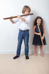 Boy and girl playing bamboo flute