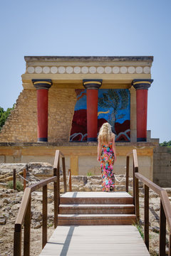 A girl in colorful dress walking to the Minoan Palace of Knossos