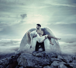 Handsome archangel carrying an innocent, unconscious lady