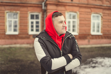 Stylish handsome young man. A young man in a black jacket walks through the old town. Stylishly dressed young man on the street. The guy in the center of the city. Travel to a European city.