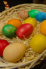 colored eggs in wicker basket 