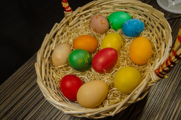 colored eggs in wicker basket 